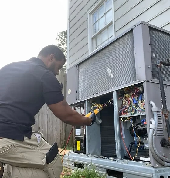 Owner Kenneth Young testing the wiring on an outdoor packaged HVAC unit